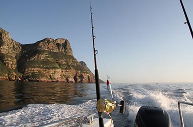 Fishing rods behind a boat leaving for a fishing charter